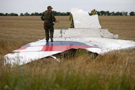 Een gewapende pro-Russische separatist staat op een brokstuk van vlucht MH17 in het oosten van Oekraïne.