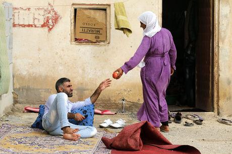 Een Koerdische vluchteling uit Kobane biedt een man een granaatappel aan in een kamp in Suruc, Turkije.