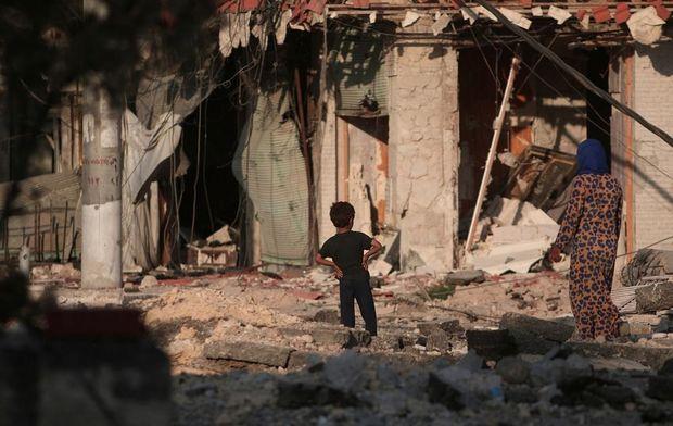 Moeder en zoon bekijken vernielingen in Manbij