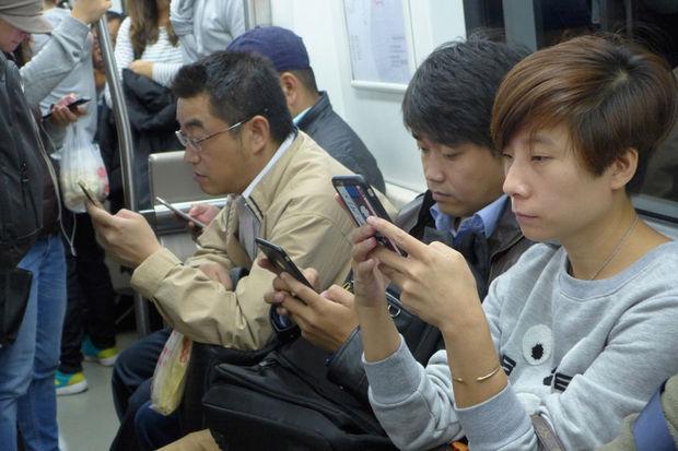 Peking, in de metro: vroeger lazen ze, nu zijn ze interactief. 