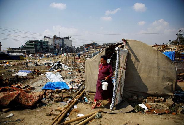 Een vrouw komt uit haar geïmproviseerd onderkomen in het verwoeste Kathmandu