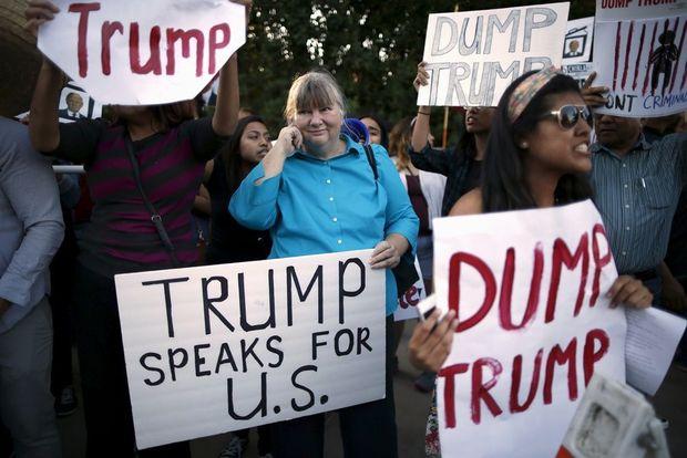Een Trump-aanhanger omringd door anti-Trump-protest