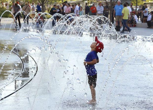 Een vijfjarige met Trump-pet geniet van het water op Public Square