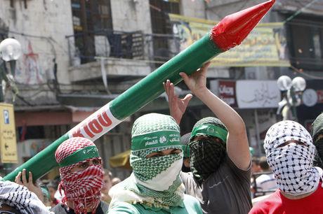 Aanhangers van Hamas met een nepraket in de West-Bank, tijdens een betoging tegen de Israëlische aanvallen op Gaza.