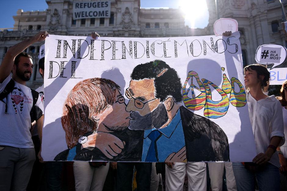 Spandoek van een kussende Puigdemont en Rajoy tijdens een mars voor dialoog op 7 oktober