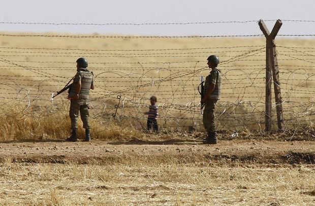 Des soldats trucs surveillent la frontière entre la Syrie et la Turquie. 
