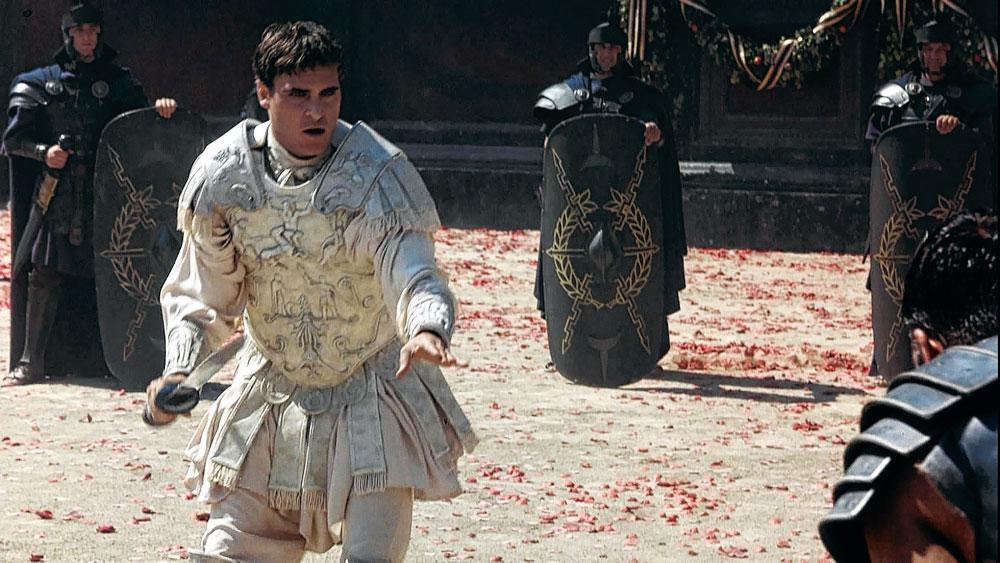 Photo du tournage de Gladiateur (2000) dans lequel Commode (Joachim Phoenix) foule le sable de l'arène. Selon toute vraisemblance, l'empereur fut assassiné sous l'ordre de sa concubine lors d'une répétition d'un spectacle auquel il prenait lui-même part.