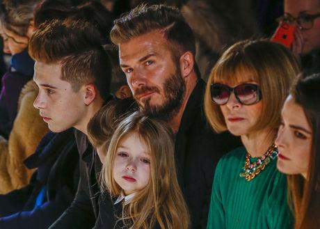 Ook Harper Beckham (3) zit tjdens de modeshow van haar moeder met haar gedachten elders en staart triest voor zich uit.