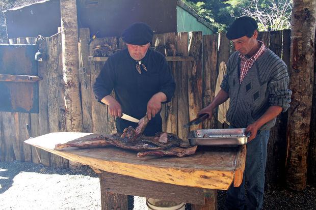 Twee (op deze foto wel Chileense) gaucho's prepareren een stuk vlees. 