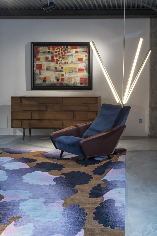 Historische objecten naast hedendaagse stukken: een fauteuil van Giò Ponti onder een lamp van Michael Anastassiades, op een tapijt van Pierre-Marie Agin.