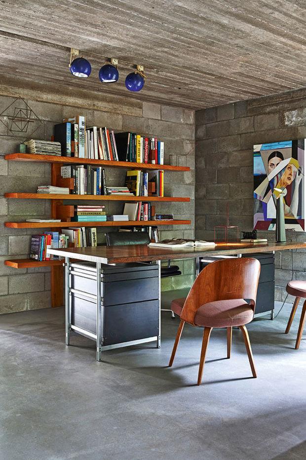 Het bureau met een werktafel van Jules Wabbes en originele Saarinen-stoelen. Het schilderij is van de jonge kunstenaar Stefaan De Croock.