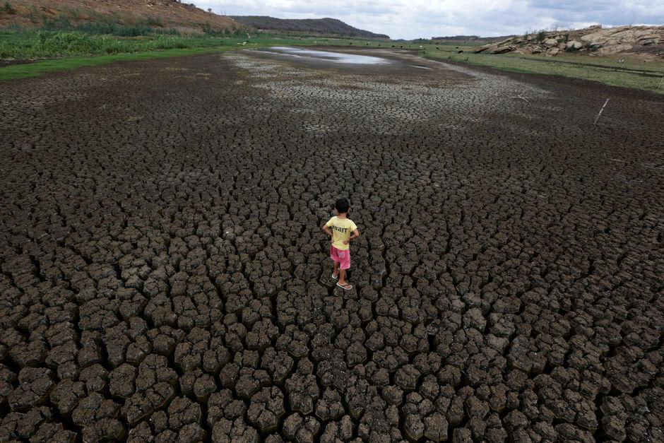 Natan Cabral, 5 en kind van landbouwers, bekijkt de grond van het quasi lege Boqueirao reservoir. Het gevolg van vijf jaar droogte.