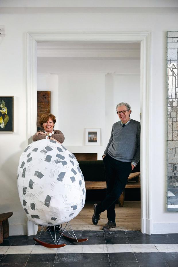 Karin en Xavier Donck hebben een passie voor hedendaagse beeldende kunst. Hier leunt Karin op het werk 'Endless Eames' van Tobias Putrih, opgevat als een enorm ei op een schommelstoel van Eames.