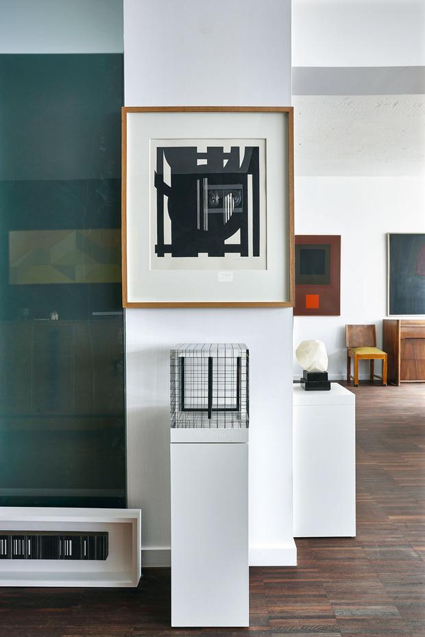Links op de grond: een werk van Luc Peire, daarnaast de kubus van Mark Verstockt en daarboven een werk van Guy Vandenbranden. Op de achtergrond: werk van Victor Noel en ernaast een olieverfschilderij van Gilbert Swimberghe. 