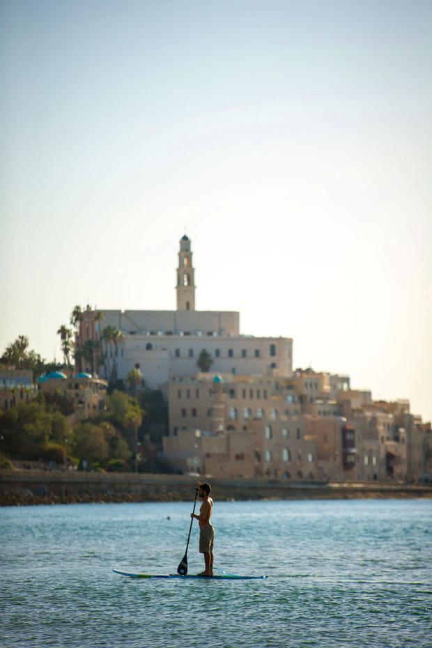 Een paddleboarder voor de kust van Jaffa.