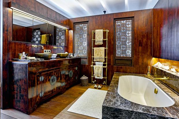 De badkamer en de slaapkamer zijn geïnspireerd op het Sjanghai van de jaren dertig met weelderige materialen, zoals bruin marmer en donker hout. Het lavabomeubel is een gerecycleerde Chinese kast.