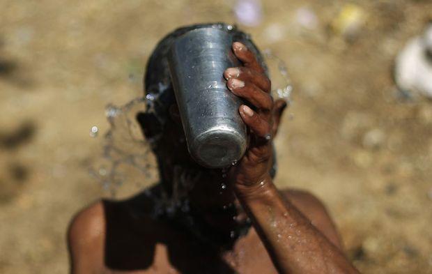 A man bathes by the roadside on a hot day in New Delhi, India, April 8, 2016.  REUTERS/Adnan Abidi - RTSE4EB