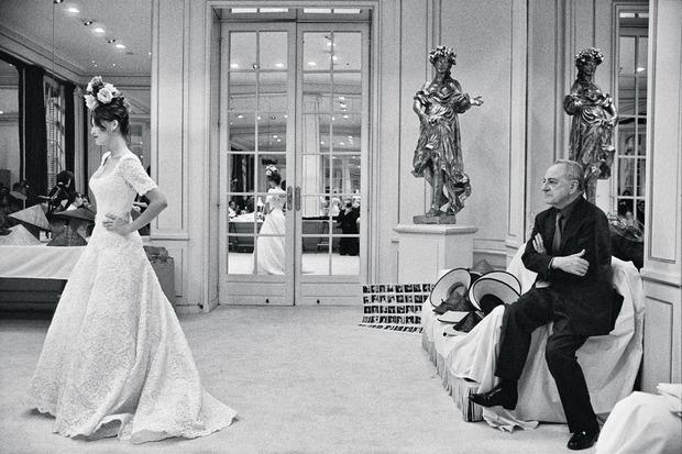 1999. Pierre Bergé, zakenpartner en voormalige levenspartner van Yves Saint Laurent (2008), kijkt toe hoe Laetitia Casta een bruidsjurk showt.