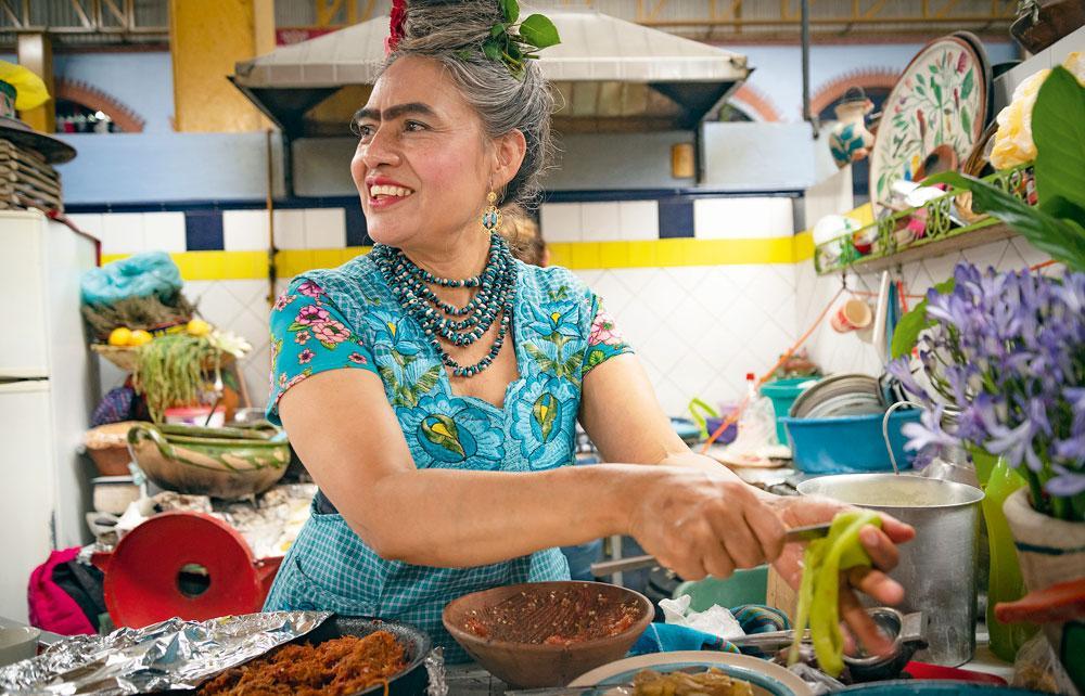 Beatriz Vázquez Gómez in haar eetstalletje La Cocina de Frida op de markt van Ocotlán. Als lookalike werd ze zelf een toeristische attractie.
