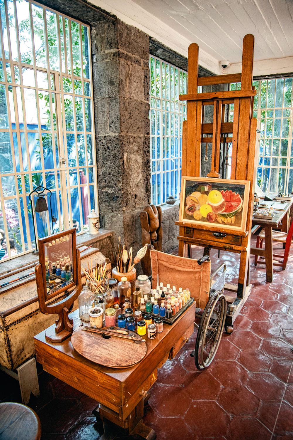 Frida's atelier, met haar ezel, haar spiegel, haar verf en haar rolstoel.