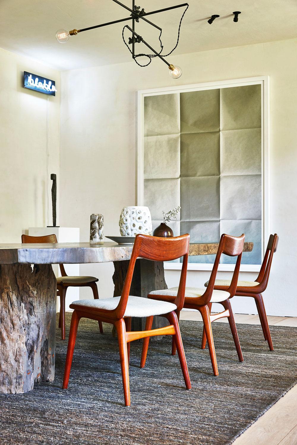 In de eetkamer staat een grote tafel van mahoniehout met daarrond Boomerang Chairs van Eric Christensen. Het kunstwerk Blabla is van Delphine Boël, het papieren werk van Leon Vranken.