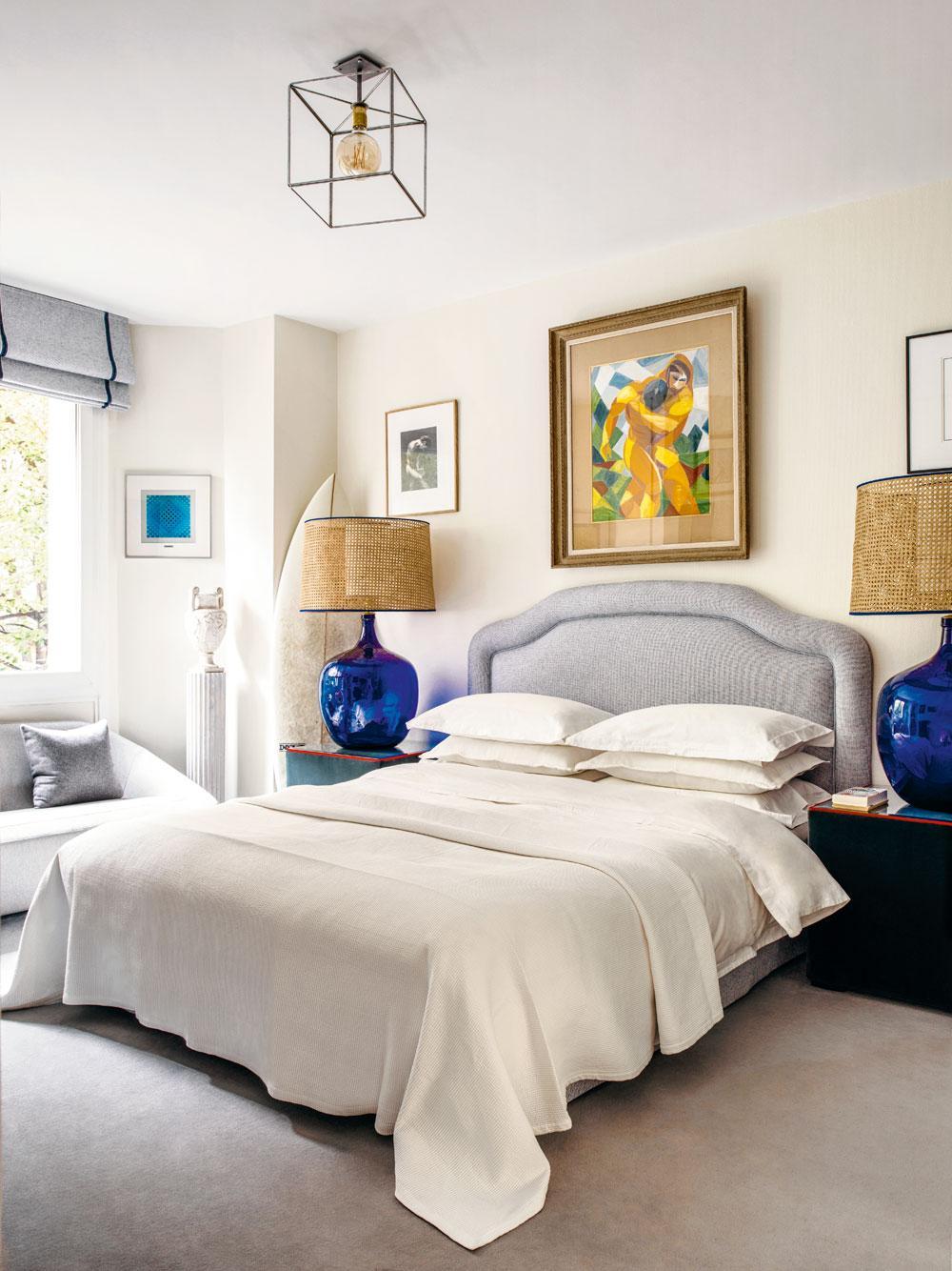 De twee blauwe lampen in de slaapkamer zijn gemaakt van Dame Jeanne-vazen.