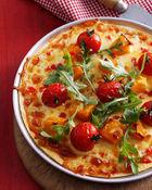 Pizza met tomaat, pompoen en rucola
