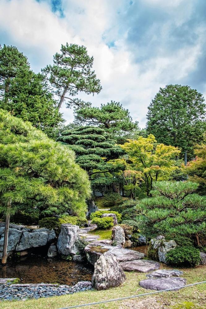 Een typische Japanse tuin, met laagjes in diepte en hoogte, een waterpartij en rotsen.