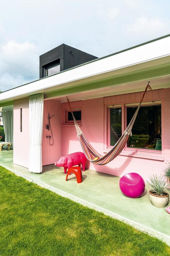 Een hangmat, zitnissen en een buitendouche creëren een 'leefruimte in de tuin'.