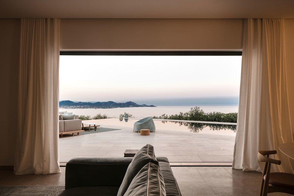 De woonkamer en het terras kijken uit over de baai van Saint-Tropez. Vooraan de fluwelen sofa van Flexform, met in het verlengde een outdoorfauteuil van Paola Lenti.