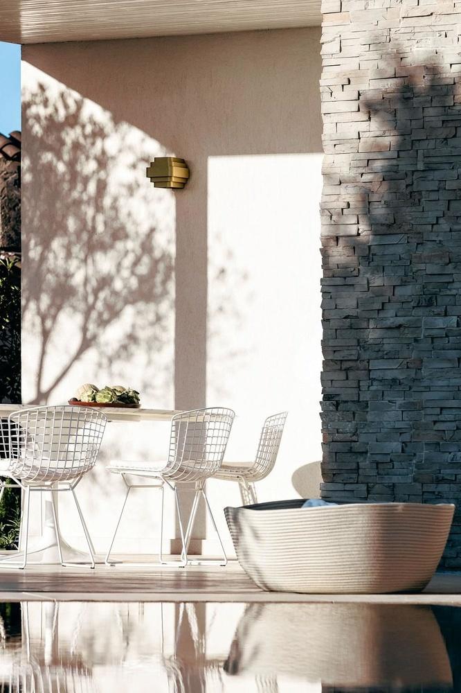 Bij de outdoor-versie van Saarinens Tulip-tafel staan draadstoelen van Bertoia. De lamp is van Jules Wabbes, de mand van Paola Lenti.