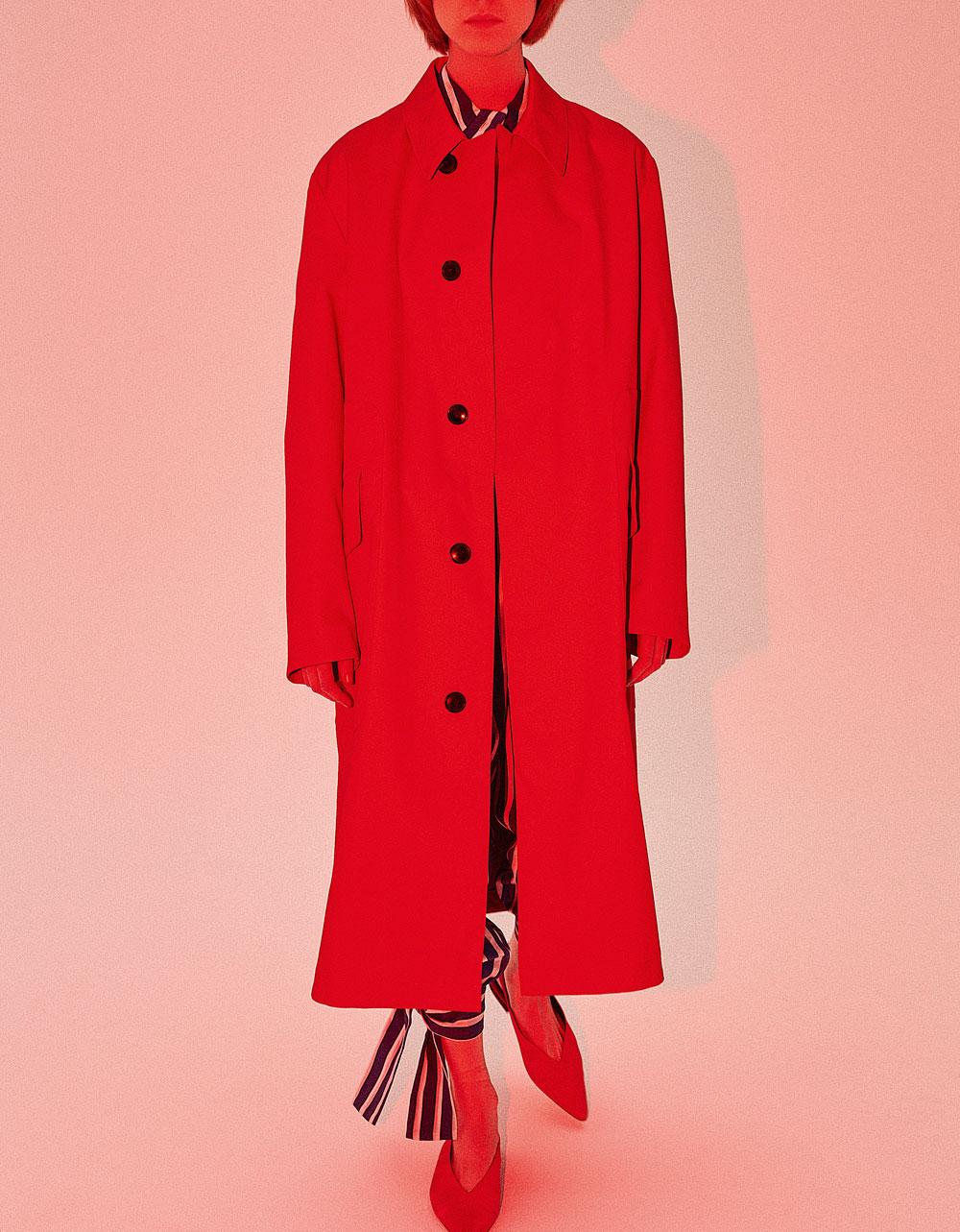 Lang gestreept zijden hemd met bijbehorende broek, by Malene Birger. Oversized rode regenmantel van gabardine, Hugo. Suède puntschoenen, Gestuz.