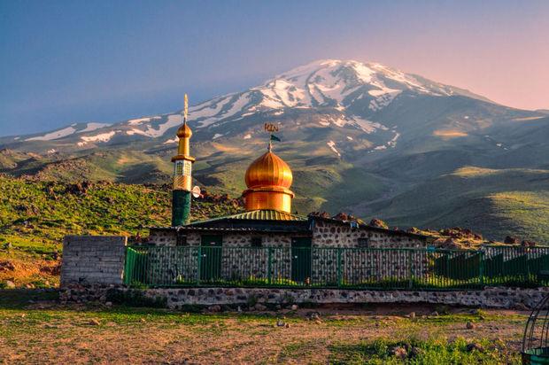 Moskee met een uivormige koepen met op de achtergrond Damavand, met 5610 meter de hoogste berg in Iran 