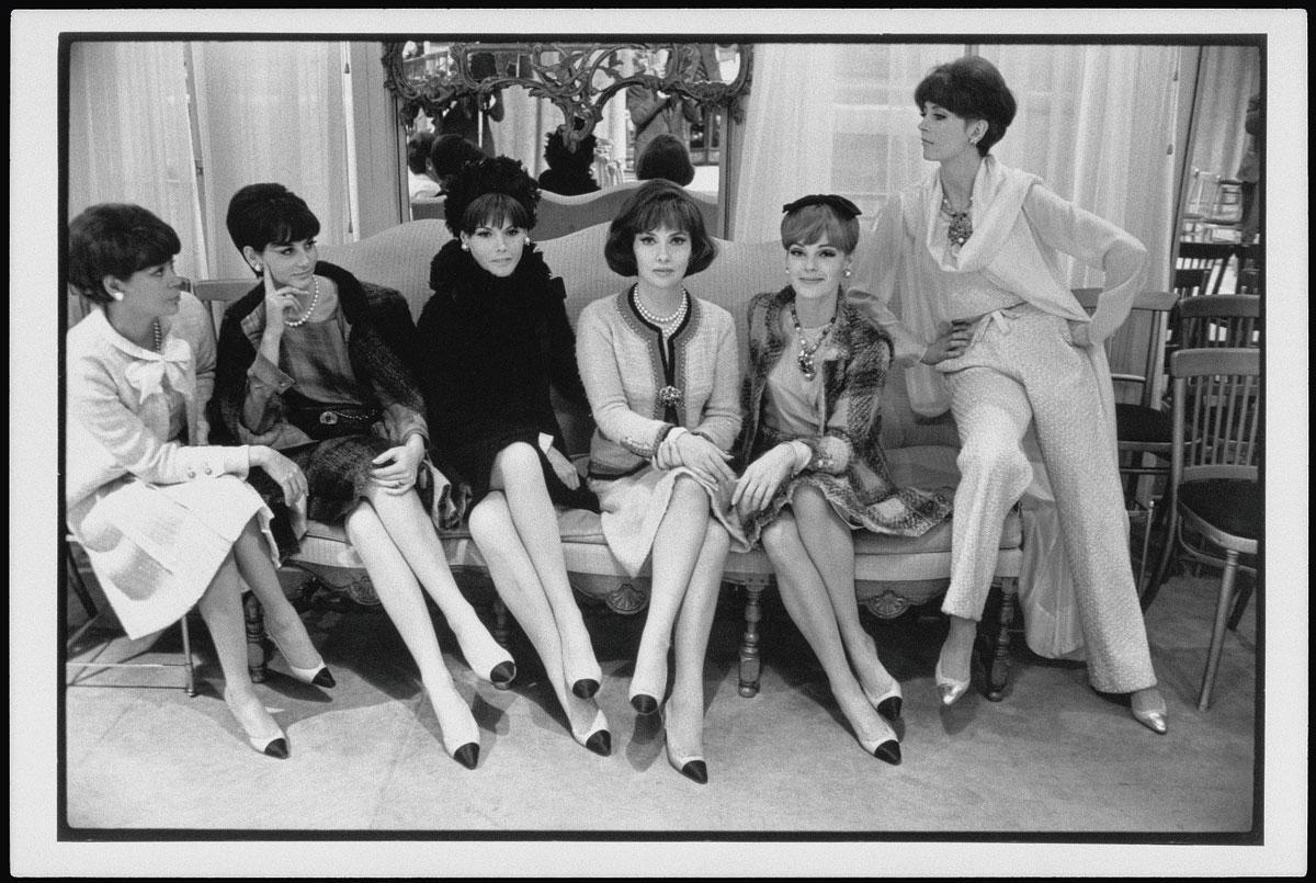 De Italiaanse actrice Gina Lollobrigida omringd door Chanel-modellen in mantelpakjes en tweekleurige schoenen (collectie herfst-winter 1964).