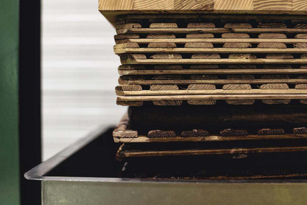 Om te persen wordt de moromi in een kaasdoek geschept en tussen twee houten plankjes zachtjes onder druk gezet.