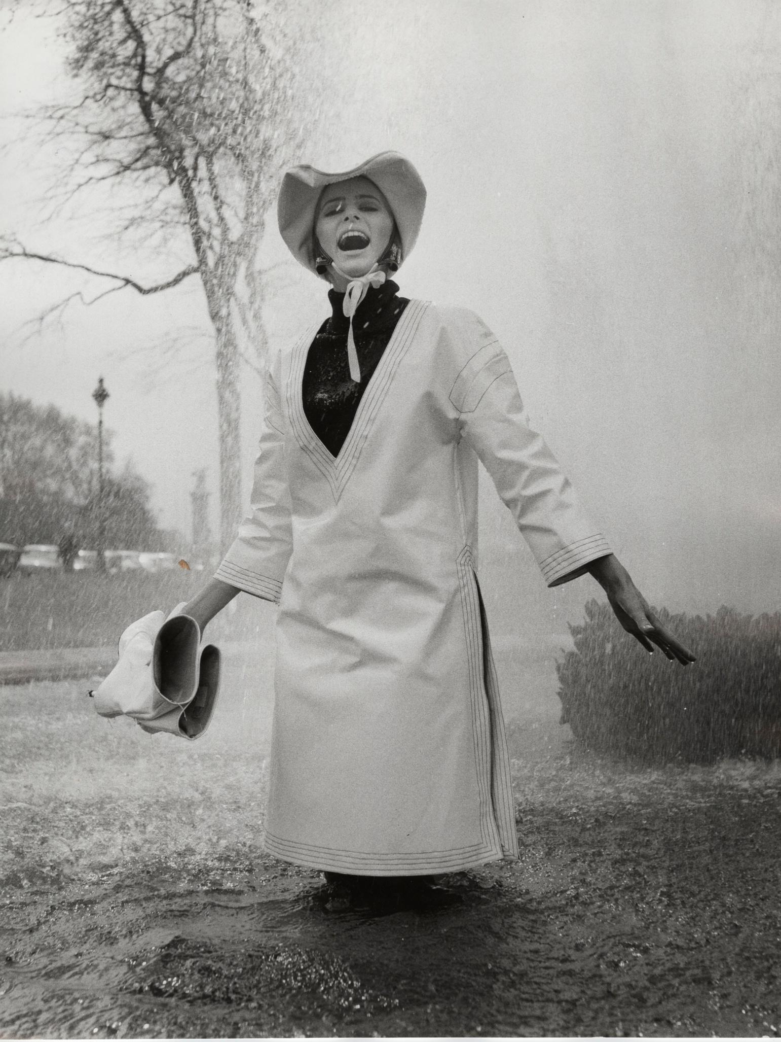 Model Jill Kennington in een witte pvc regentuniek en hoed, 1963 (fotograaf: John Cowan)
