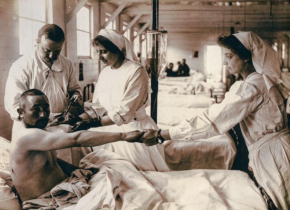 Laura, gantée, soigne un blessé de l'hôpital chirurgical de Cabour, le 21 mai 1915.