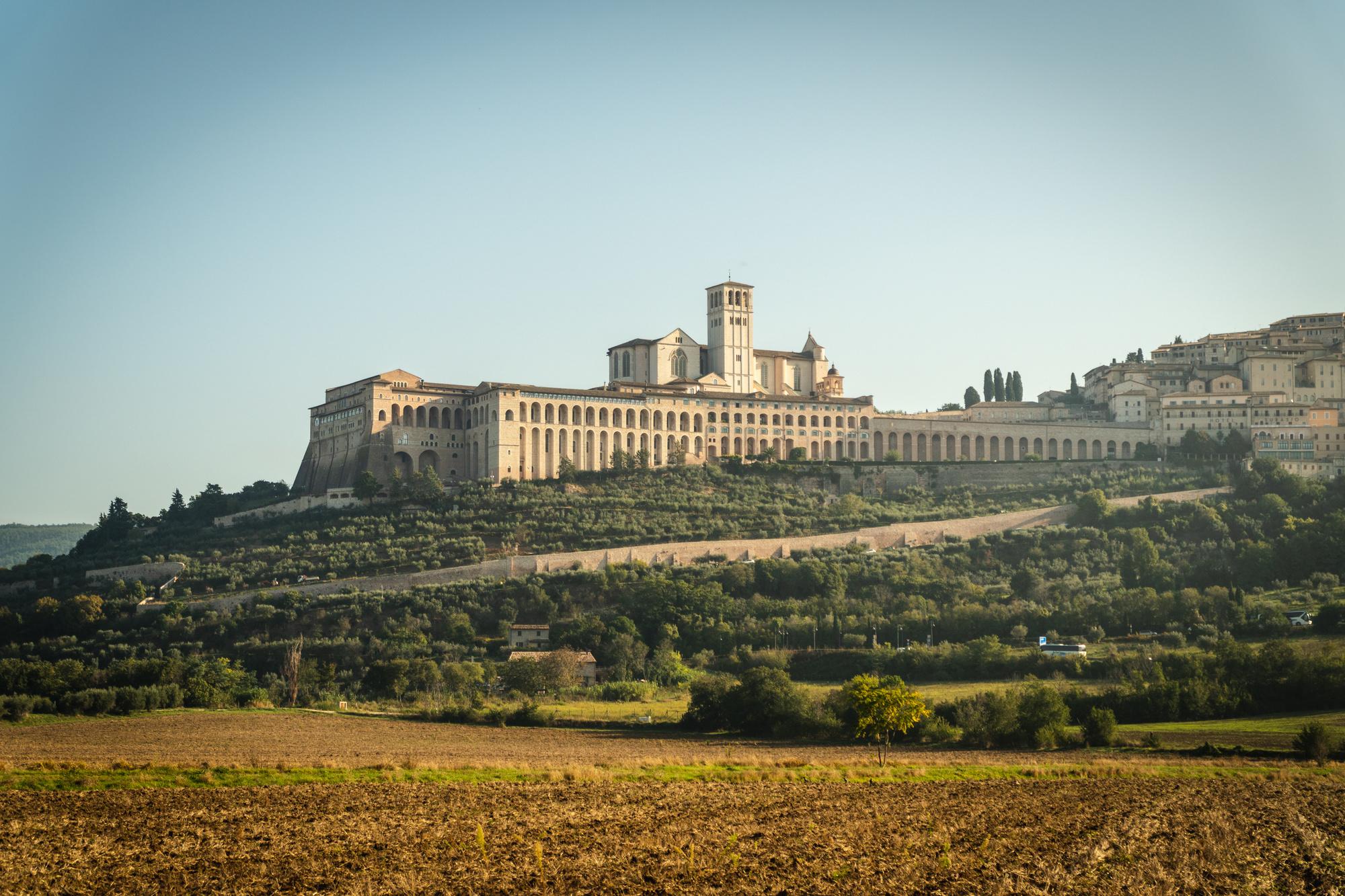 Op de berg zie je Assisi, het gebouw onderaan is het hotel Borgo Antichi Orti.