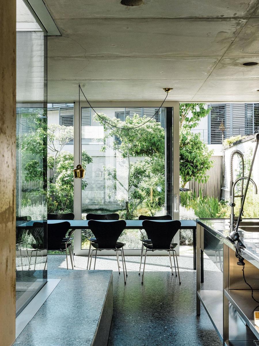 de achterbouw met granitovloer en industriële keuken is een ontwerp van architect Greg Geertsen. Boven de tafel met vlinderstoelen van Fritz Hansen hangt een messing lamp van Artek.