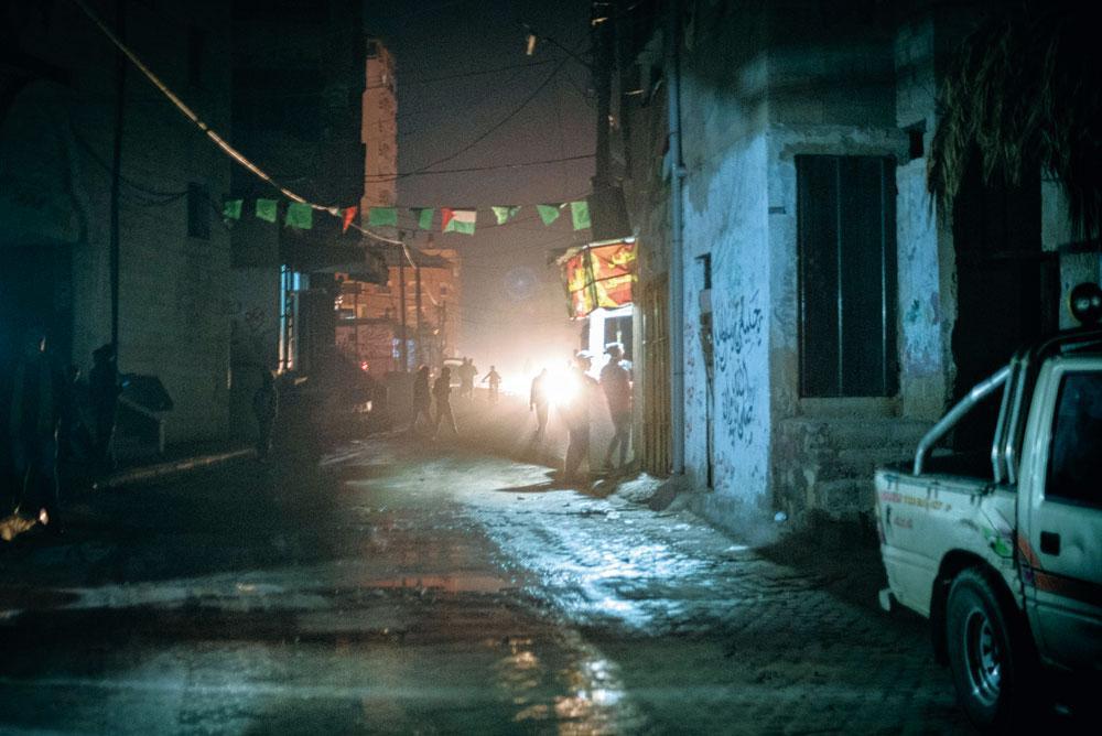 Des habitants de Khan Younès, petite ville dans le sud de la bande de Gaza, s'éclairent comme ils peuvent, au moyen des phares d'une voiture.