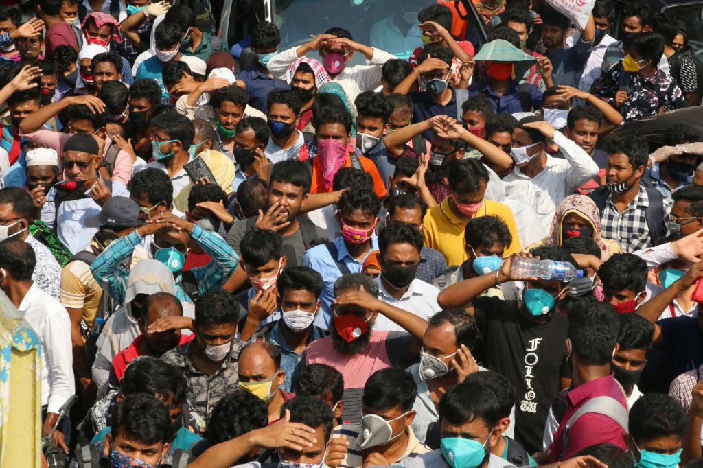 Duizenden kledingareiders op weg naar Dhaka om hun job te redden, ondanks de dreiging van het coronavirus. Zelfisolatie is in Bangladesh haast onmogelijk.