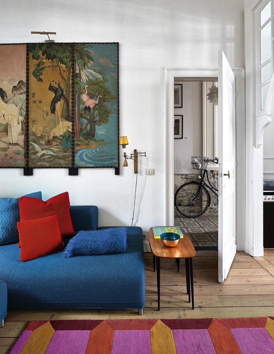 Het pronkstuk van het interieur - een paravent uit 1963 - 'erfden' Charlotte en Kristof van de vorige eigenaar. Hij wordt in de woonkamer gecombineerd met een blauwe sofa van Cinna, een tapijt van Ikea en een set vintage koffietafeltjes, gevonden bij Arrangerie 13 in Antwerpen.