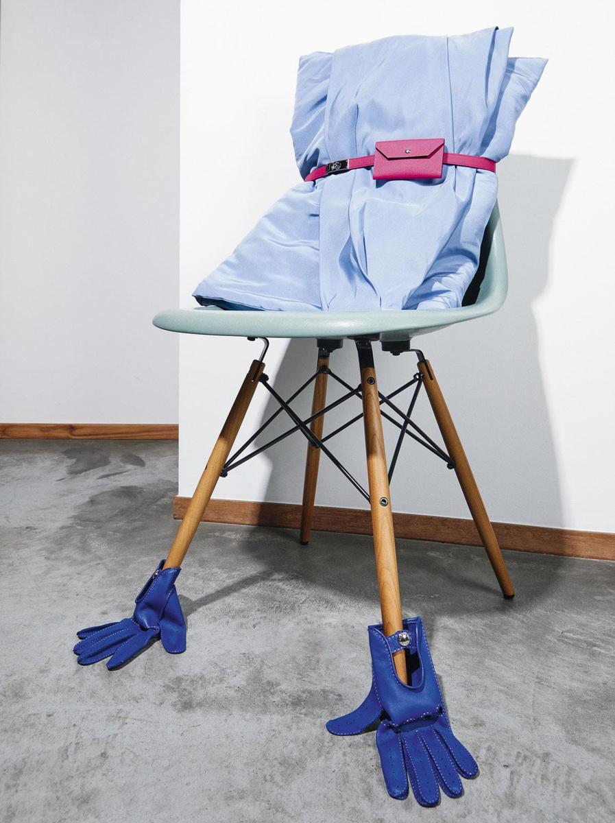 Eames Fiberglass Side Chair DSW, van Charles & Ray Eames (1950), Vitra Antwerpen. Grote clutch in lichtblauwe satijn, Natan. Fuchsia leren riem met opbergzakje en koningsblauwe lamsleren handschoenen, Hermès.