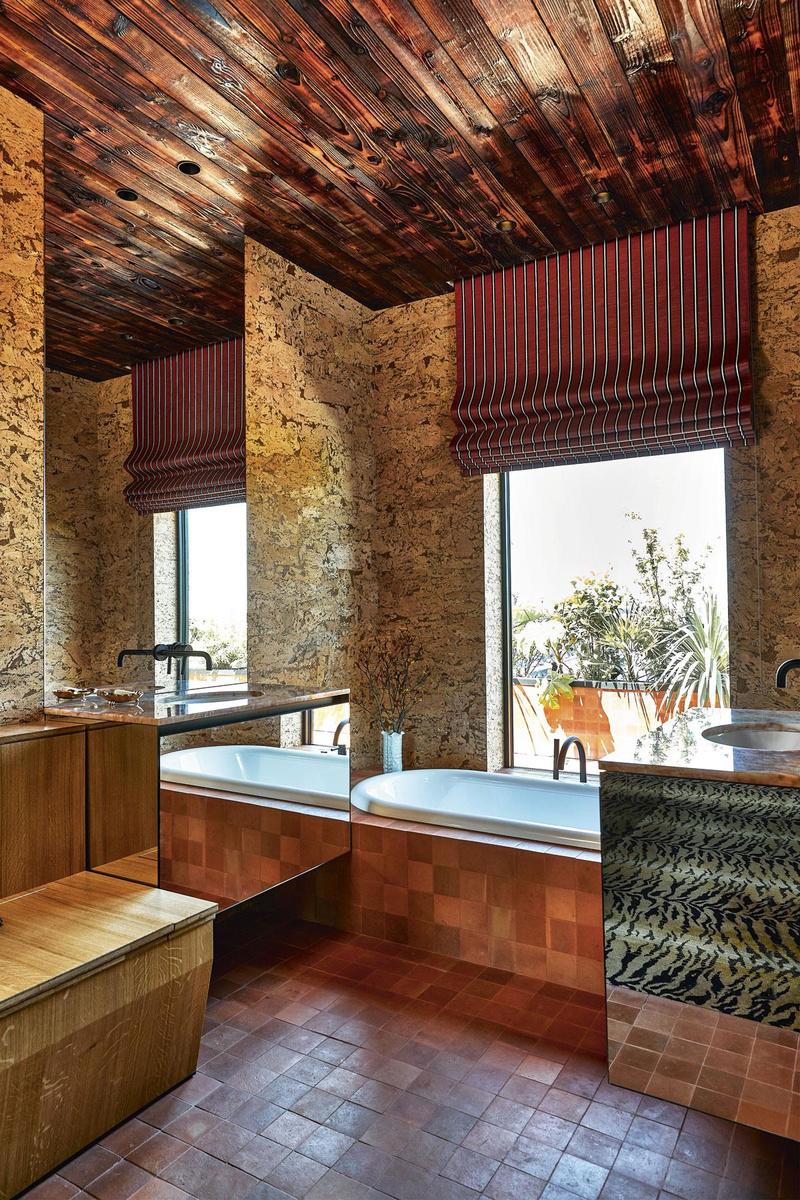 De wandbekleding van kurk zorgt voor een aangename akoestiek in de badkamer, die uitkijkt over de tropische daktuin.