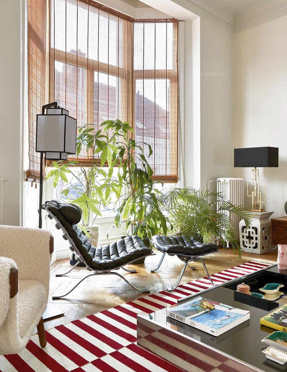 De leren loungestoel en bijpassende ottoman uit 1966 zijn van de Zweedse ontwerper Arne Norell. Morgane combineert de set met een rood-wit tapijt van Ikea, een salontafel van Willy Rizzo en een lampionlamp die ze meebracht uit Londen.