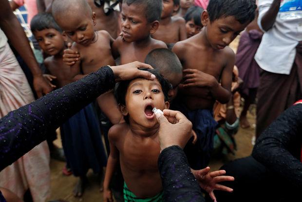 Un enfant, réfugié Rohingya, reçoit un vaccin distribué par l'OMS, avec l'aide de bénévoles et d'associations locales, dans un camp de réfugiés près de Cox's Bazar, Bangladesh, 2017.