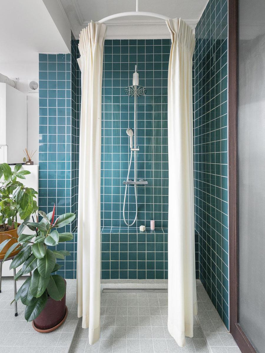 In de  douche hangt een gordijn dat aan dat van een pashokje doet denken.
