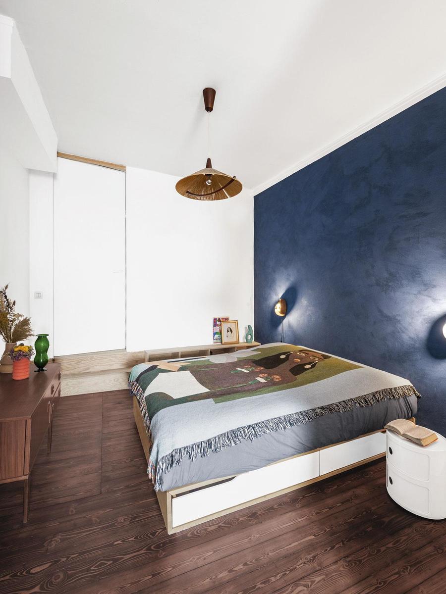 In de slaapkamer zonder ramen versterkt de nachtblauwe muur nog meer het cocooneffect.