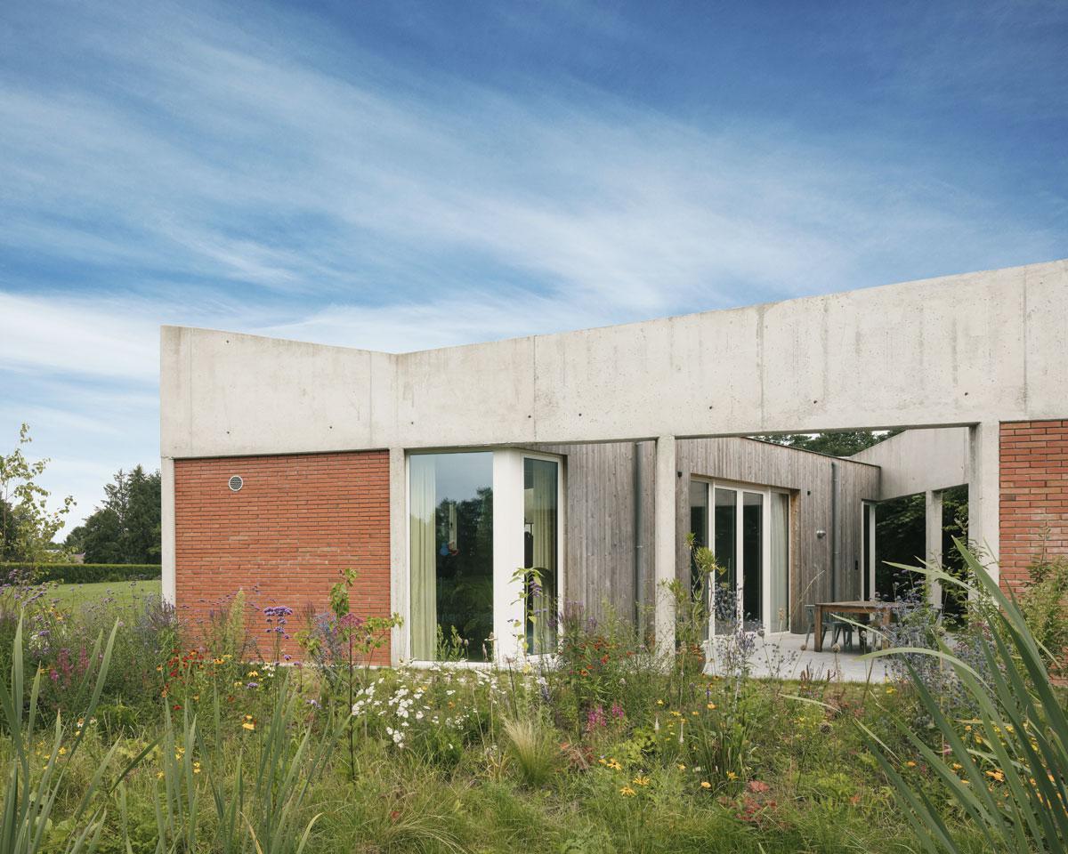 Het betonnen kader op pilaren werd deels ingevuld met bakstenen. Hans liet zich voor de wilde tuin door de Nederlandse landschapsarchitect Piet Oudolf inspireren.