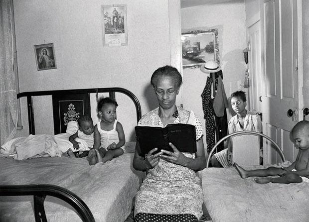 Ella Watson lisant la Bible à sa famille. A travers cette femme de ménage pieuse, qu'il a également photographiée balais en main sous le drapeau américain, Gordon Parks illustre et dénonce la ségrégation raciale.